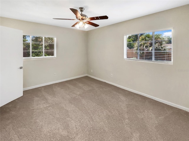 carpeted spare room with a wealth of natural light and ceiling fan