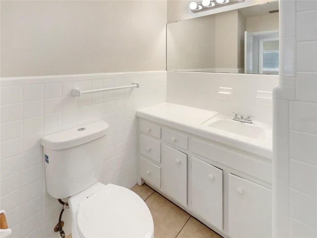 bathroom with tile patterned flooring, vanity, toilet, and tile walls