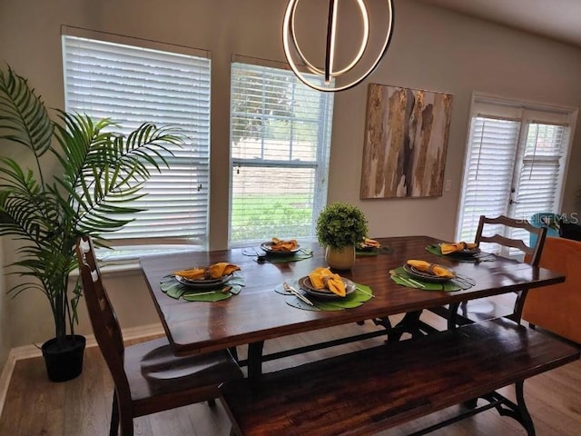 dining area featuring plenty of natural light, an inviting chandelier, and wood-type flooring