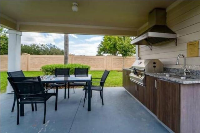 view of patio with sink, an outdoor kitchen, and a grill