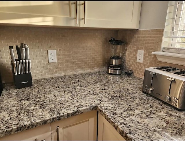 kitchen featuring stone counters and backsplash