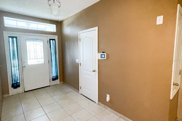 tiled foyer featuring plenty of natural light and a textured ceiling