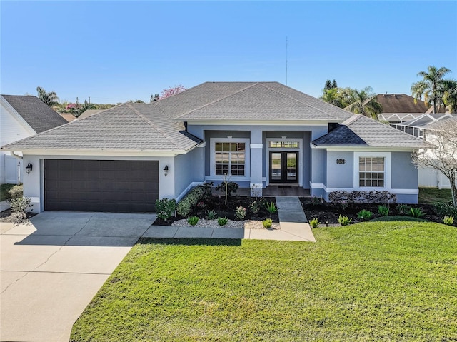 view of front facade with french doors, a front yard, and a garage