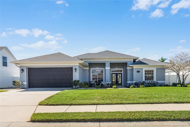 prairie-style home featuring a garage and a front lawn