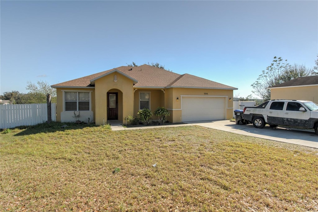 single story home with a front yard and a garage