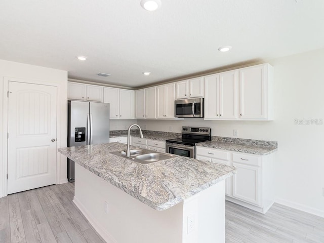 kitchen featuring white cabinetry, sink, a center island with sink, and appliances with stainless steel finishes