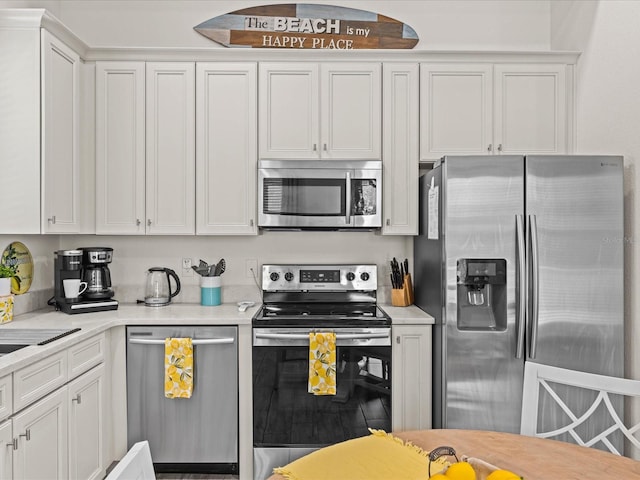 kitchen featuring stainless steel appliances and white cabinetry