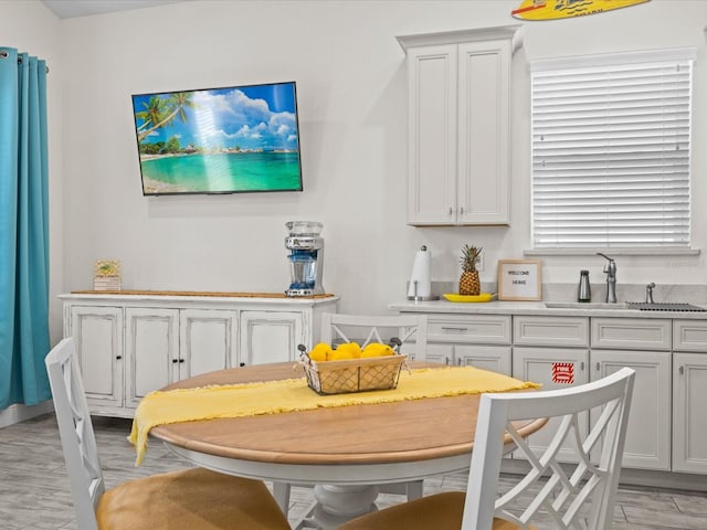 dining area with sink and light hardwood / wood-style flooring