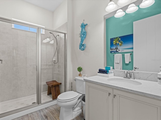 bathroom featuring an enclosed shower, large vanity, toilet, and wood-type flooring