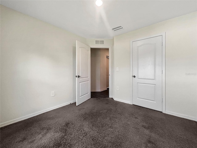 unfurnished bedroom with dark carpet