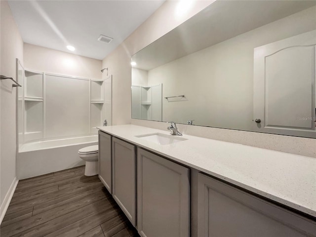 full bathroom featuring hardwood / wood-style floors, vanity, toilet, and shower / washtub combination