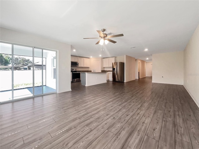 unfurnished living room with ceiling fan and light hardwood / wood-style flooring