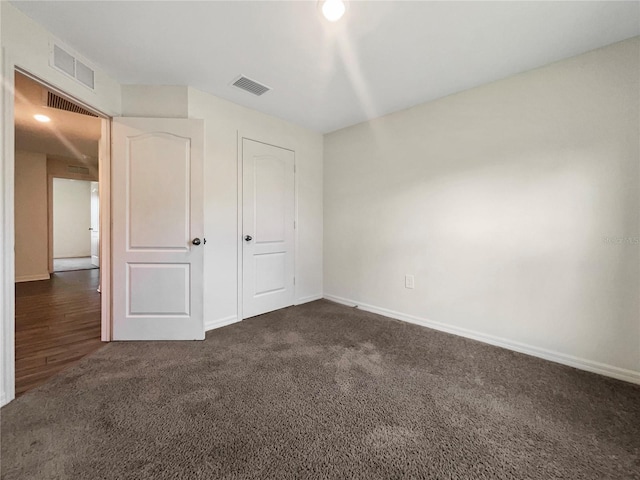 unfurnished bedroom with a closet and dark hardwood / wood-style floors