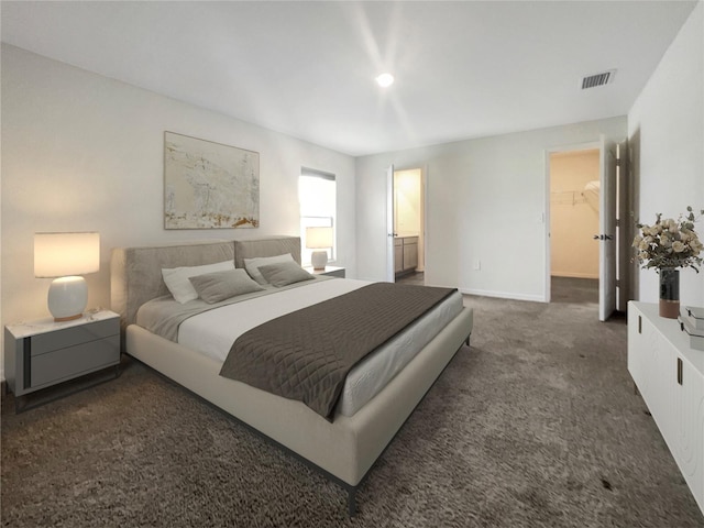 carpeted bedroom featuring connected bathroom, a closet, and a walk in closet