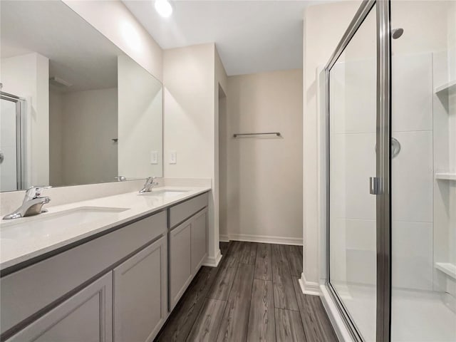 bathroom with a shower with door, hardwood / wood-style floors, and vanity