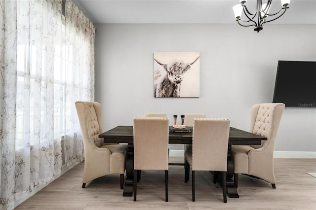 dining space with a chandelier and light wood-type flooring