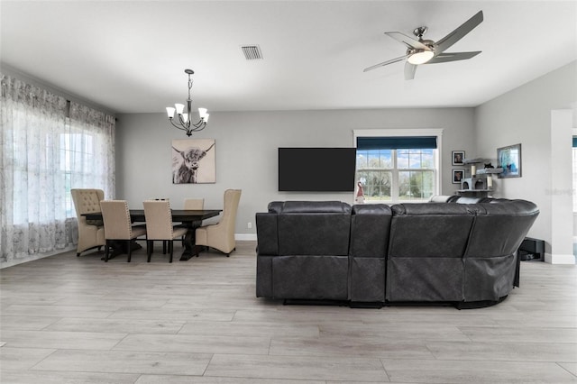 living room featuring light hardwood / wood-style floors and ceiling fan with notable chandelier