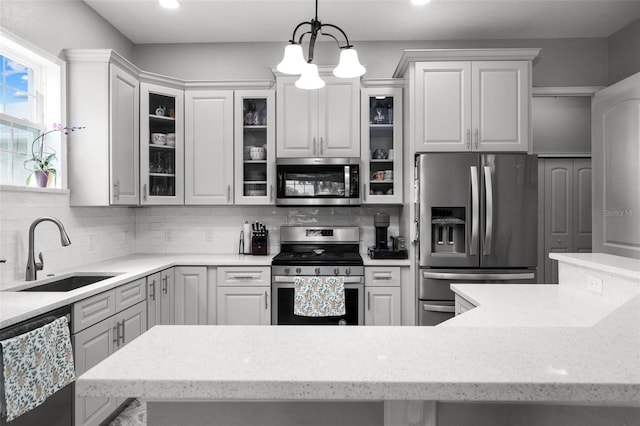 kitchen featuring decorative light fixtures, white cabinetry, backsplash, a notable chandelier, and appliances with stainless steel finishes