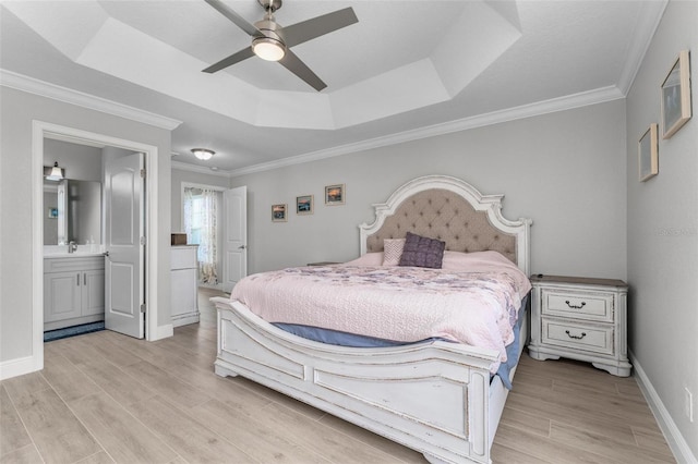 bedroom featuring ceiling fan, crown molding, a raised ceiling, and ensuite bathroom