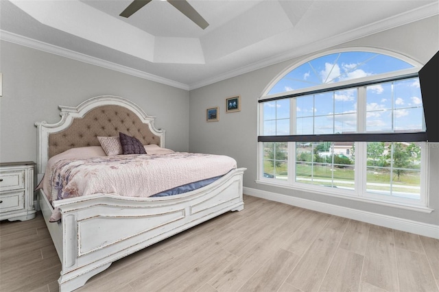 bedroom featuring a raised ceiling, ornamental molding, ceiling fan, and light hardwood / wood-style flooring