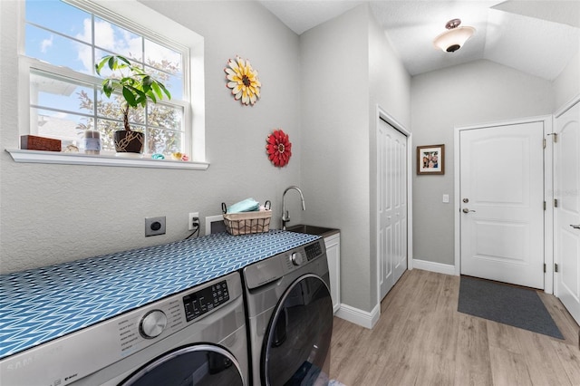 laundry room with electric dryer hookup, light hardwood / wood-style floors, cabinets, washer and clothes dryer, and sink