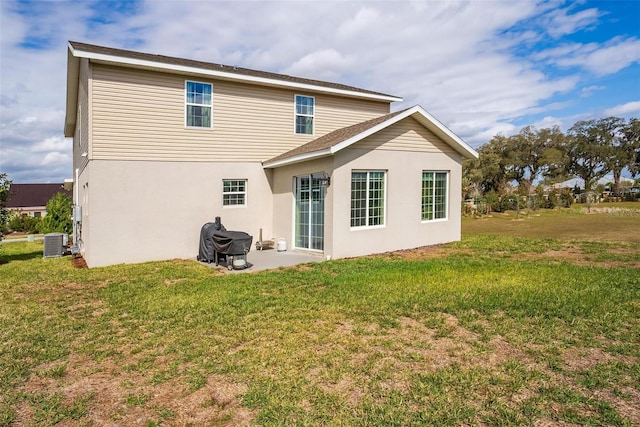 back of property featuring a lawn and central AC unit