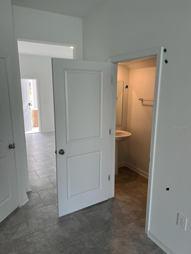 hallway with dark tile flooring