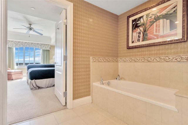 bathroom with tile flooring, ceiling fan, and tiled bath