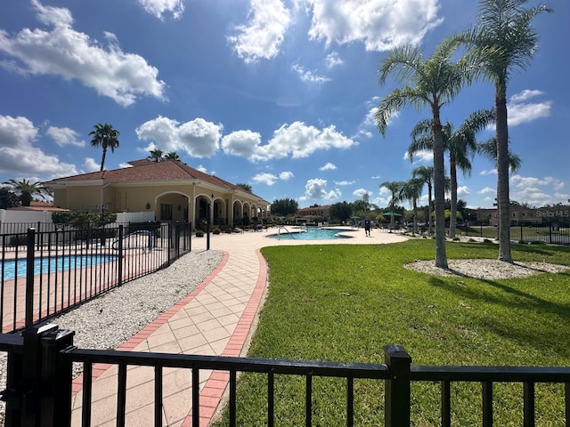 view of pool featuring a patio and a yard