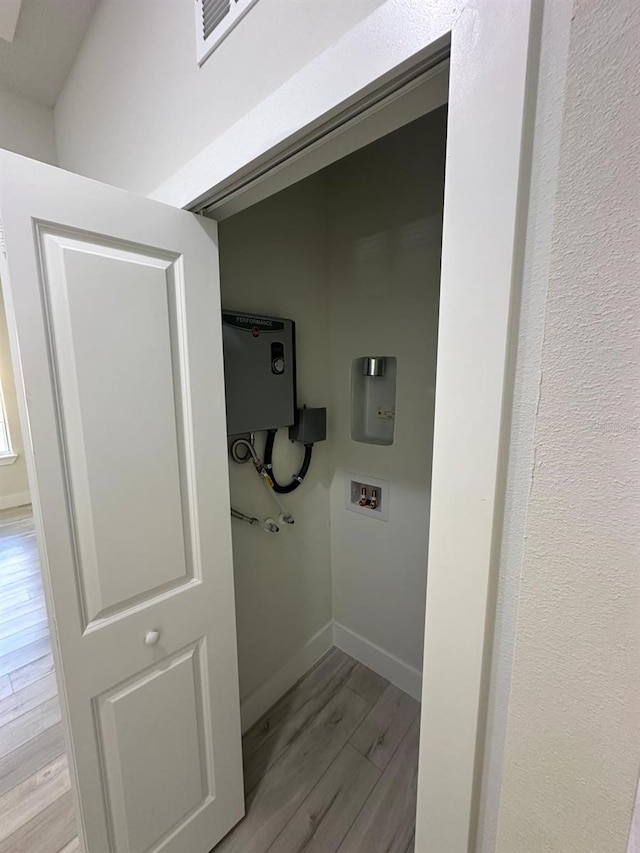 laundry area with light hardwood / wood-style floors and washer hookup