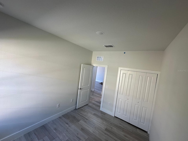 unfurnished bedroom featuring light hardwood / wood-style floors and a closet