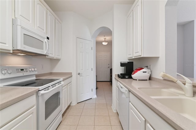 kitchen featuring white appliances, sink, white cabinetry, and light tile floors