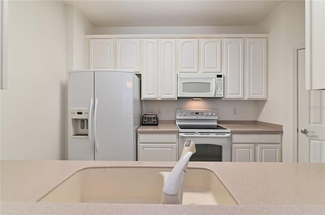 kitchen featuring white appliances and white cabinets