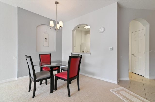 dining space featuring light carpet and a notable chandelier