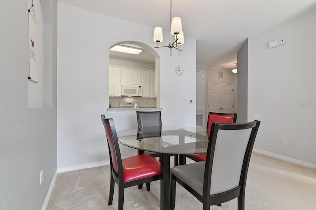 dining room featuring light colored carpet and a notable chandelier