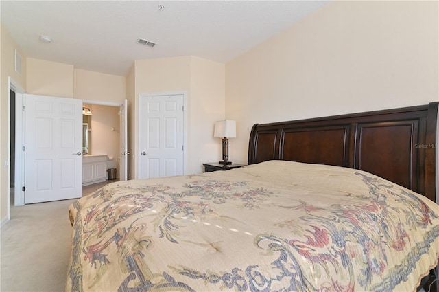 bedroom featuring light carpet and ensuite bathroom