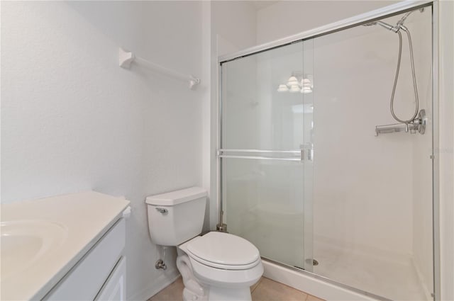 bathroom featuring tile floors, toilet, vanity, and a shower with shower door