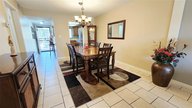 tiled dining space featuring an inviting chandelier