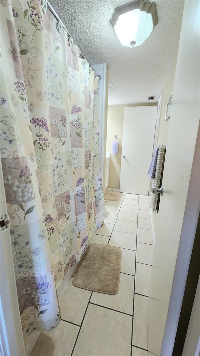 bathroom featuring tile floors and a textured ceiling