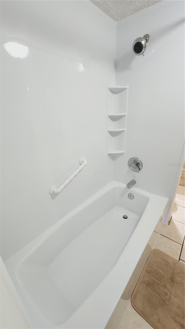 bathroom featuring tile flooring, a textured ceiling, and tub / shower combination