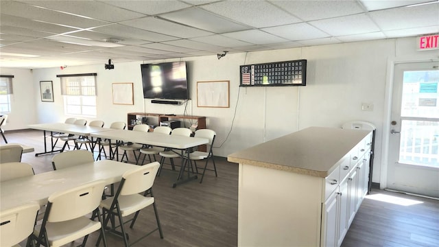 interior space with dark wood-type flooring and a drop ceiling