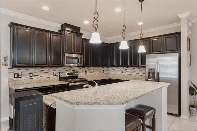 kitchen featuring stainless steel appliances, an island with sink, pendant lighting, and decorative backsplash