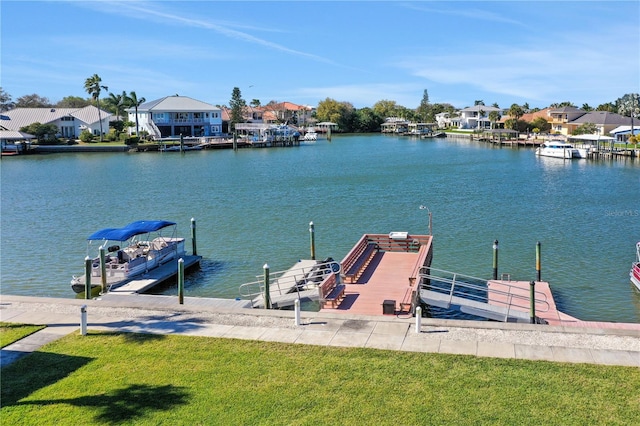 view of dock featuring a lawn and a water view