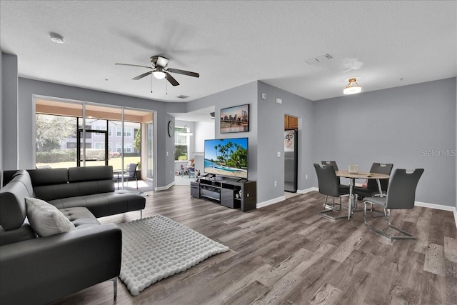 living room featuring hardwood / wood-style floors, a textured ceiling, and ceiling fan