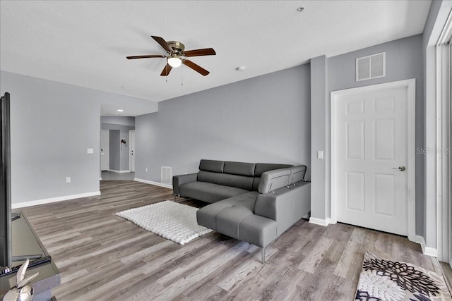 living room featuring ceiling fan and wood-type flooring