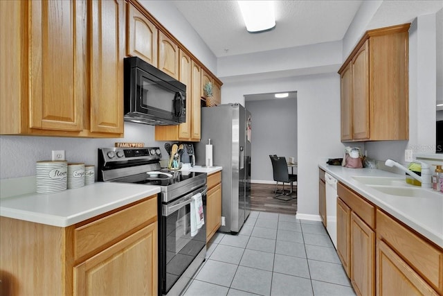 kitchen with stainless steel fridge, electric stove, sink, light tile floors, and white dishwasher