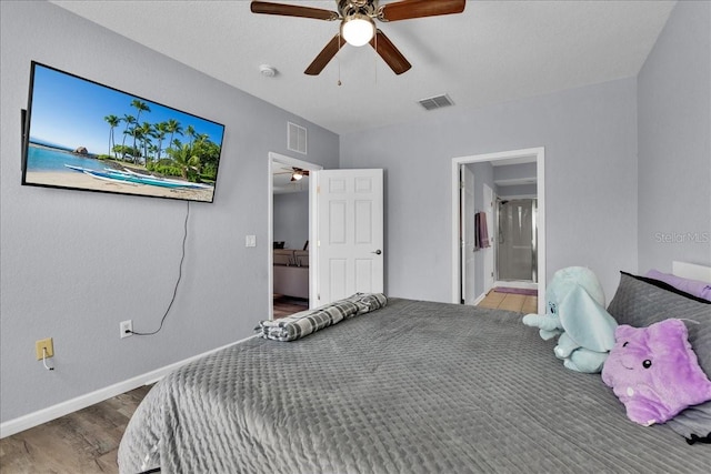 bedroom with ensuite bath, ceiling fan, and dark hardwood / wood-style floors