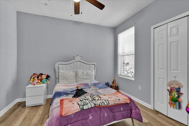 bedroom with a closet, light hardwood / wood-style floors, and ceiling fan