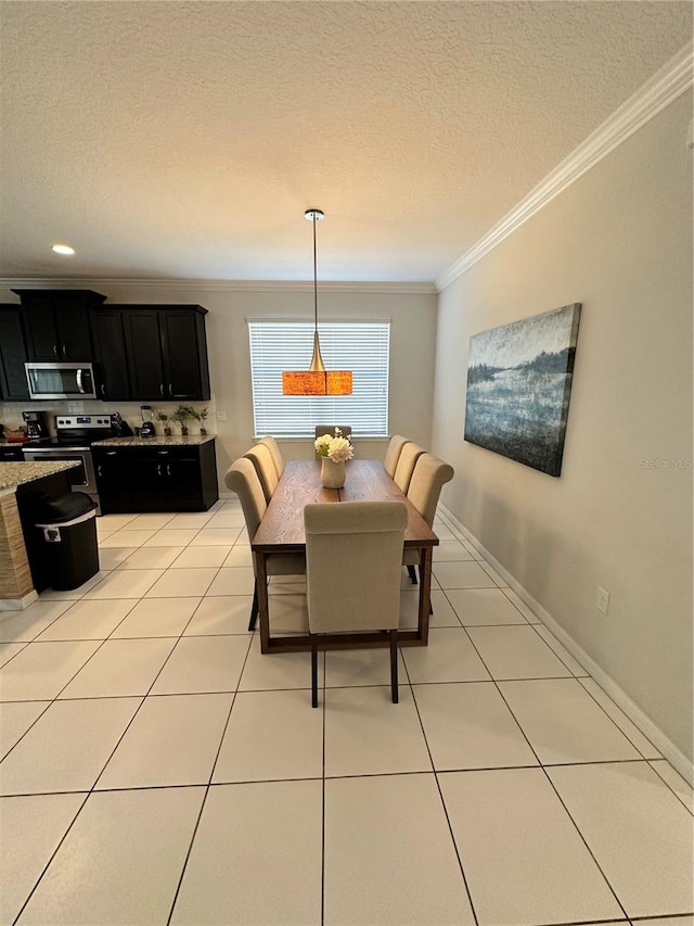 dining space featuring ornamental molding, a textured ceiling, and light tile flooring