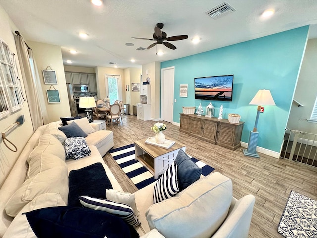 living room featuring ceiling fan and light hardwood / wood-style flooring